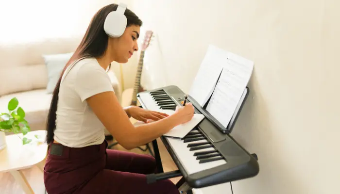 femme jouant piano seule prenant notes partition